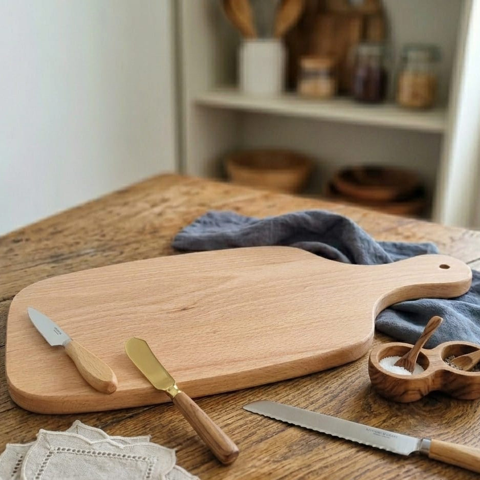 Massives Holzschneidebrett mit abgerundeten Kanten und ergonomischem Griff inklusive Aufhängeloch. Hochwertiges Küchenaccessoire aus Naturholz für Brotzeit und Apéro.