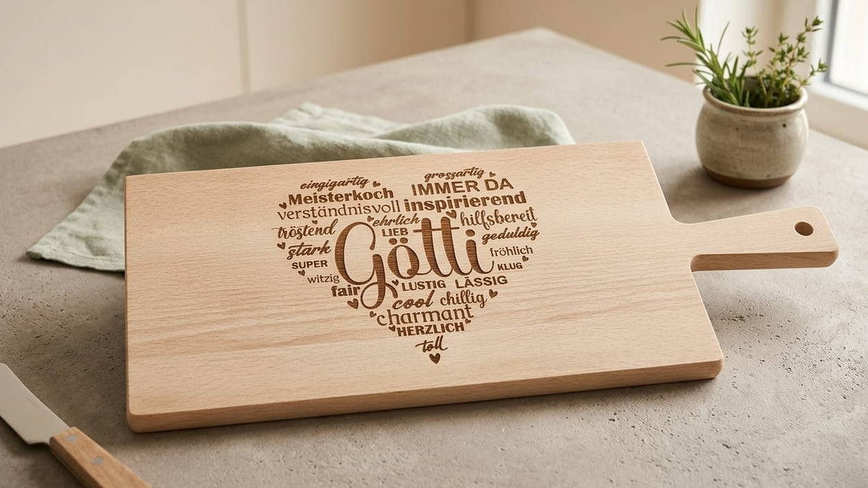 Personalisiertes Holzschneidebrett aus Buchenholz als Geschenk für den Götti – Wortwolke in Herzform mit Gravuren wie 'Meisterkoch', 'Lustig' und 'Herzlich'.