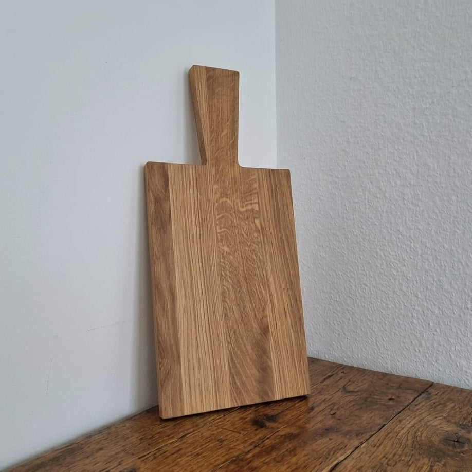 Rechteckiges Servierbrett aus Eichenholz mit markanter Maserung und praktischem Griff. Hochwertiges Holzbrett für die Küche oder als Käseplatte im Landhausstil zum Personalisieren.